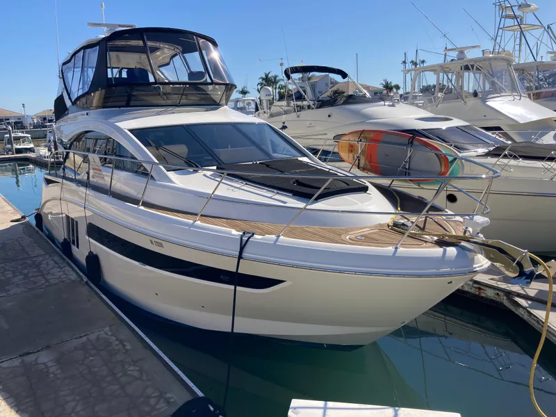 Slide: The Image of 2018 Sea Ray Fly 510 yacht docked in marina under clear blue sky. - 2
