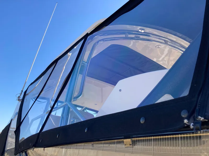 Slide: The Image of 2018 Sea Ray Fly 510 yacht with clear enclosure under a blue sky. - 22