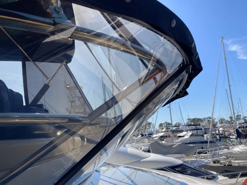 Slide: The Image of 2018 Sea Ray Fly 510 yacht in marina, showcasing sleek design and clear skies. - 23