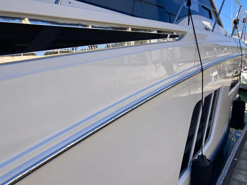 Slide: The Image of 2018 Sea Ray Fly 510 yacht side view with sleek white exterior. - 29