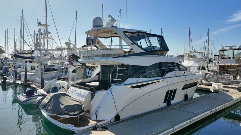 Slide: The Image of 2018 Sea Ray Fly 510 yacht docked in marina, surrounded by other boats. - 3