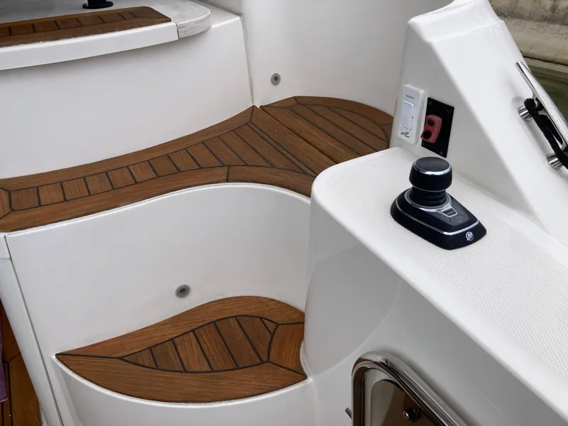 Slide: The Image of 2018 Sea Ray Fly 510 boat deck with wood finish and control joystick. - 36
