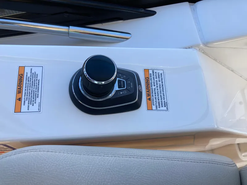 Slide: The Image of 2018 Sea Ray Fly 510 control panel with joystick and warning labels. - 39