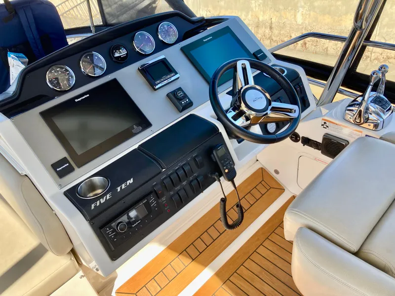 Slide: The Image of 2018 Sea Ray Fly 510 yacht helm with modern controls and navigation displays. - 46