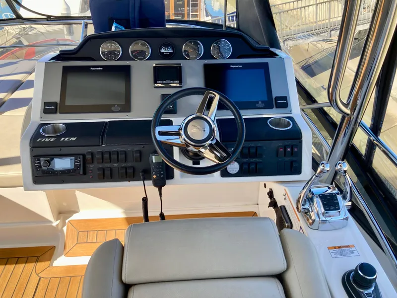 Slide: The Image of 2018 Sea Ray Fly 510 helm with modern navigation controls and steering wheel. - 47