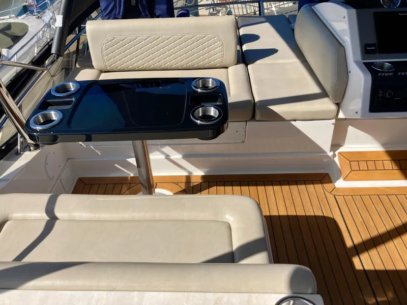 Slide: The Image of Luxurious seating area on 2018 Sea Ray Fly 510 yacht with sleek table and cup holders. - 63