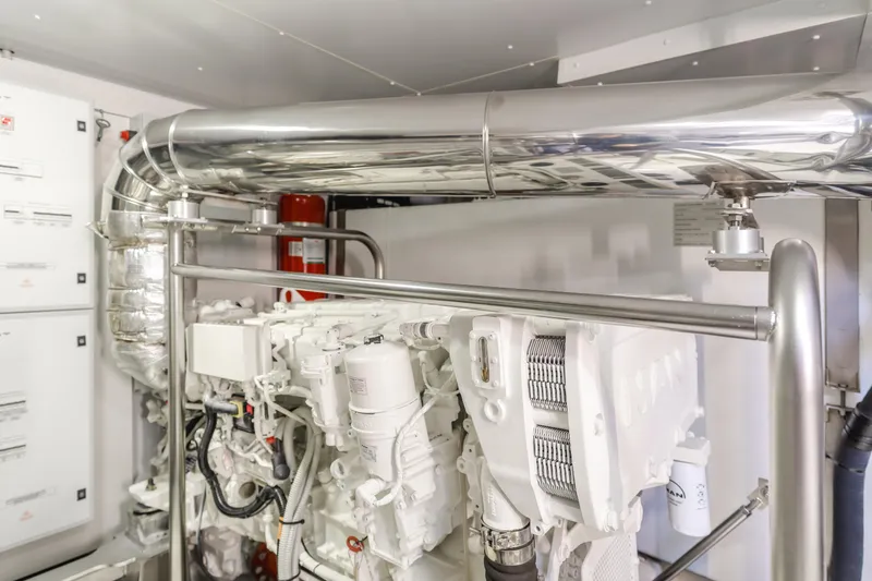 Slide: The Image of Engine room of 2023 Azimut Magellano 66 yacht, featuring modern machinery and piping. - 16