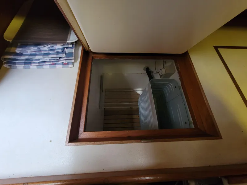 Slide: The Image of Wooden hatch opening on a Fuji 40 sailboat, revealing storage space below deck. - 13
