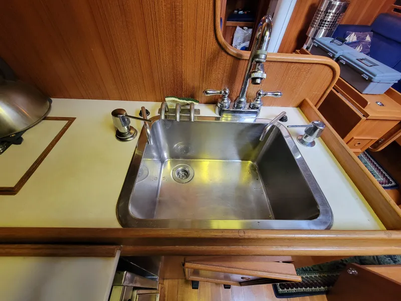 Slide: The Image of Stainless steel sink in a 1978 Fuji 40 boat kitchen with wooden cabinetry. - 16