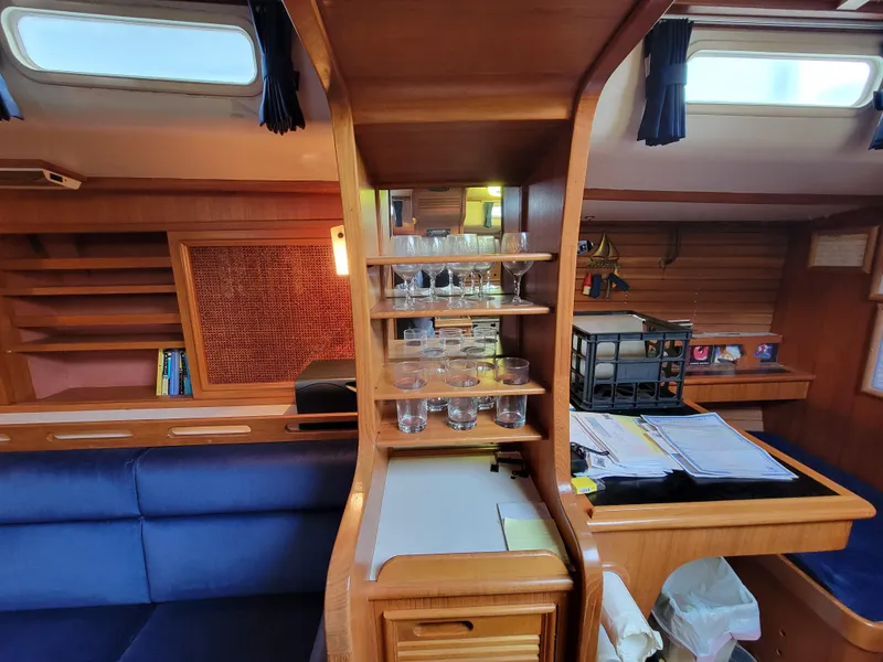 Slide: The Image of Interior of a 1978 Fuji 40 sailboat with wooden cabinetry and glassware display. - 22