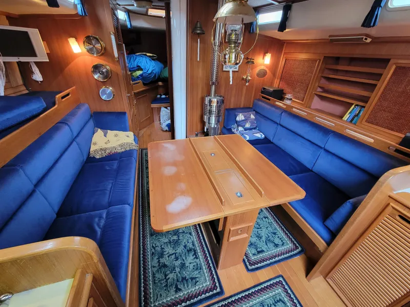 Slide: The Image of Cozy 1978 Fuji 40 yacht interior with blue seating and wooden accents. - 24