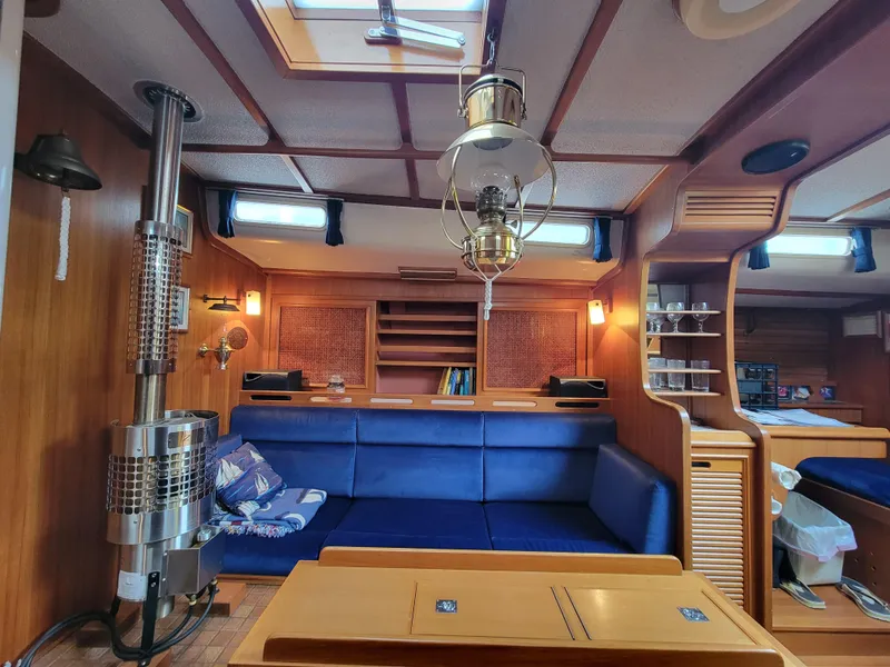 Slide: The Image of Cozy 1978 Fuji 40 yacht interior with blue seating, wood paneling, and vintage lighting. - 26