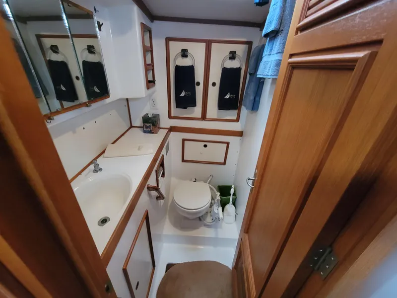 Slide: The Image of Compact 1978 Fuji 40 boat bathroom with wooden cabinets and white fixtures. - 29