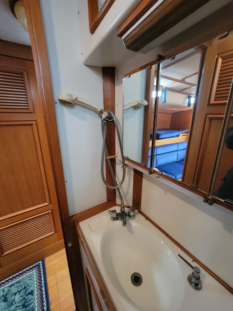 Slide: The Image of 1978 Fuji 40 yacht bathroom with sink, mirror, and wooden cabinetry. - 31