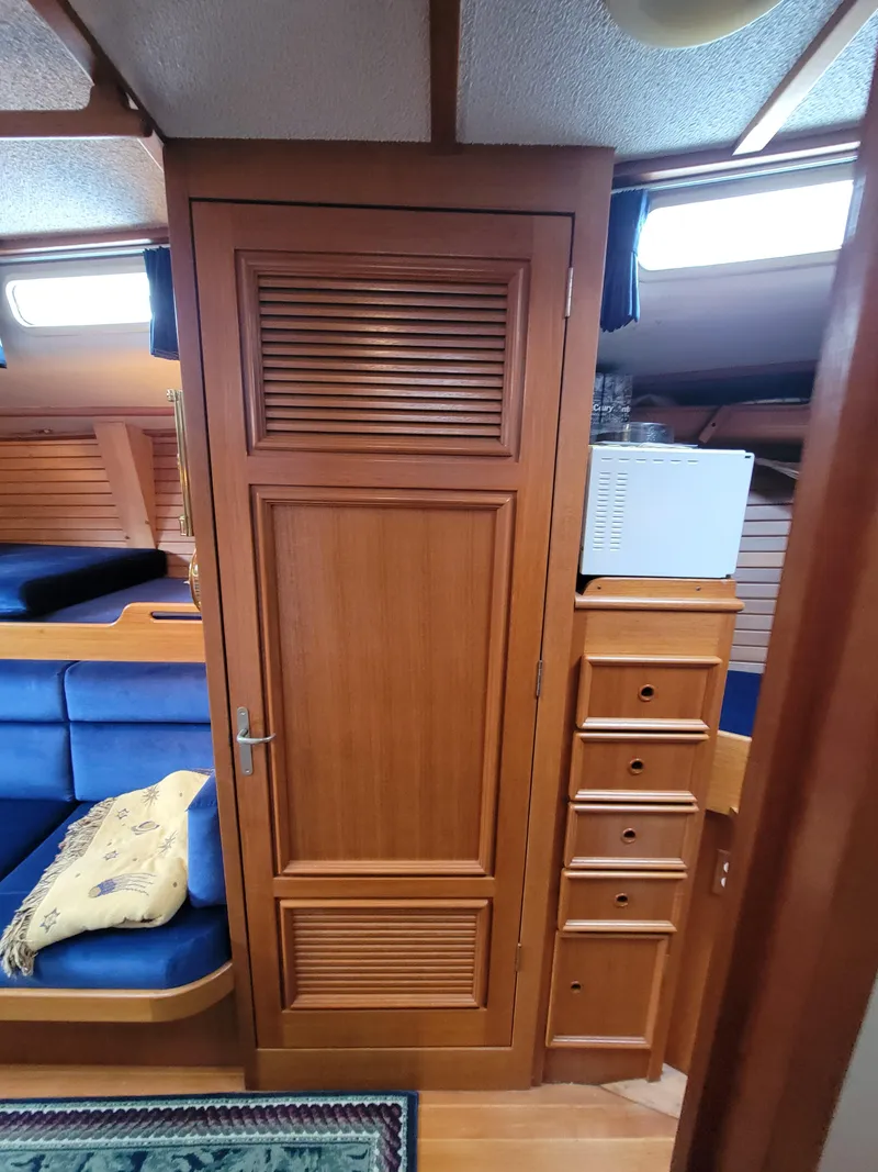 Slide: The Image of 1978 Fuji 40 yacht interior with wooden cabinetry and blue seating. - 32
