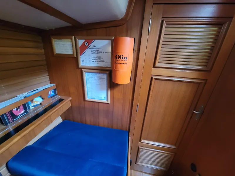 Slide: The Image of Cozy wooden cabin interior of 1978 Fuji 40 sailboat with blue seating and safety equipment. - 35