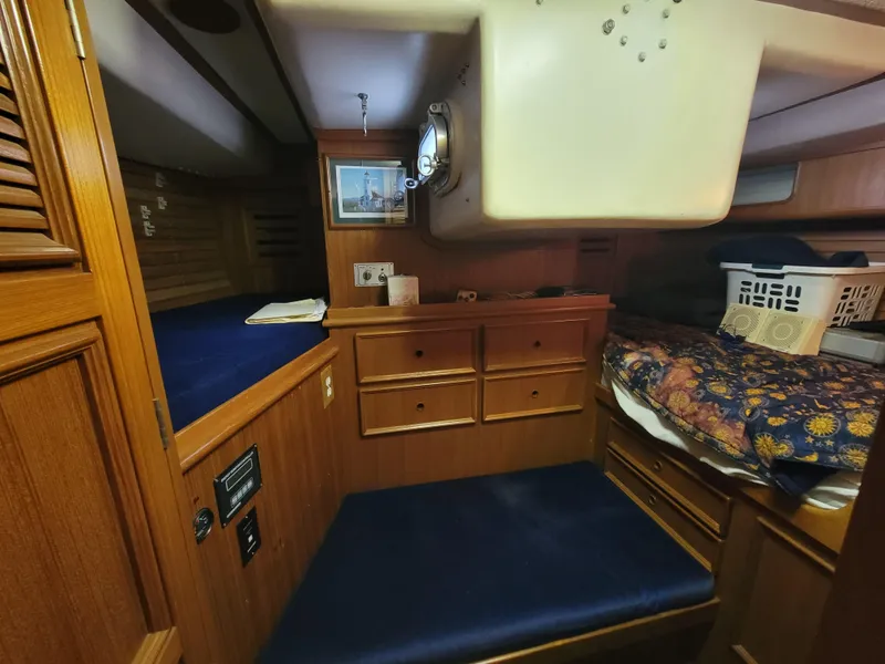 Slide: The Image of Cozy wooden cabin interior of a 1978 Fuji 40 sailboat with blue cushions and storage. - 39