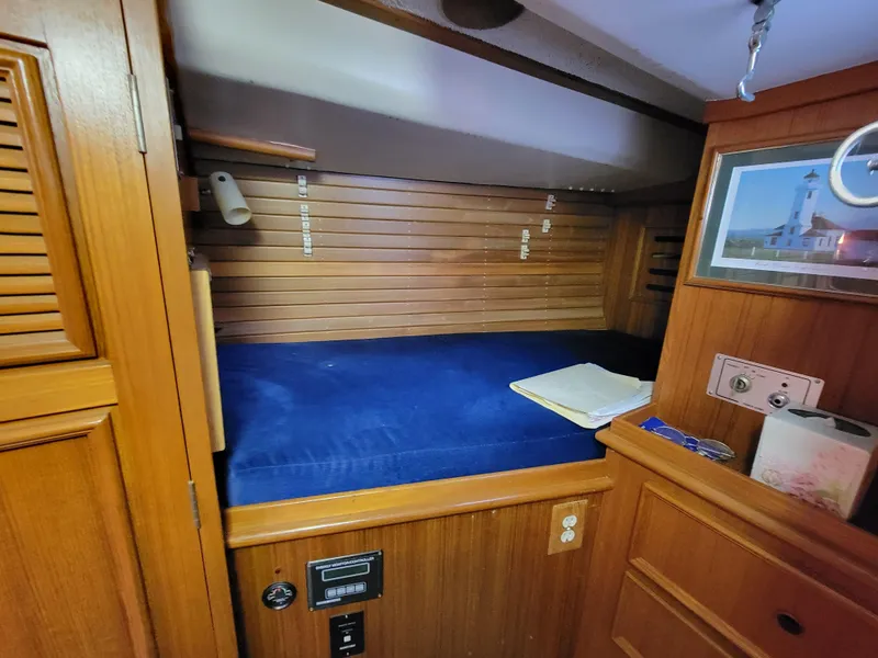 Slide: The Image of Cozy wooden cabin interior with blue bedding on a 1978 Fuji 40 sailboat. - 40
