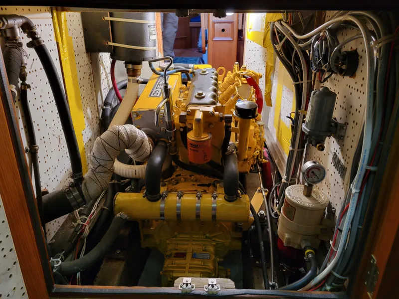 Slide: The Image of Engine room of a 1978 Fuji 40 boat, featuring a yellow diesel engine. - 49