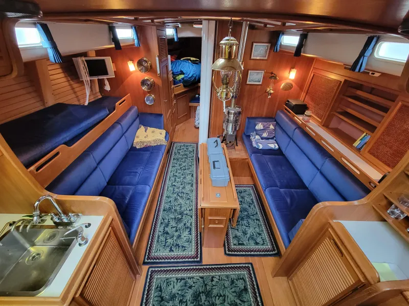 Slide: The Image of Vintage 1978 Fuji 40 yacht interior with blue seating, wooden finishes, and nautical decor. - 8