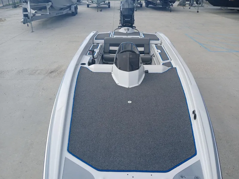 Slide: The Image of 1988 Allison 2002 XB boat with gray deck, parked on concrete. - 12