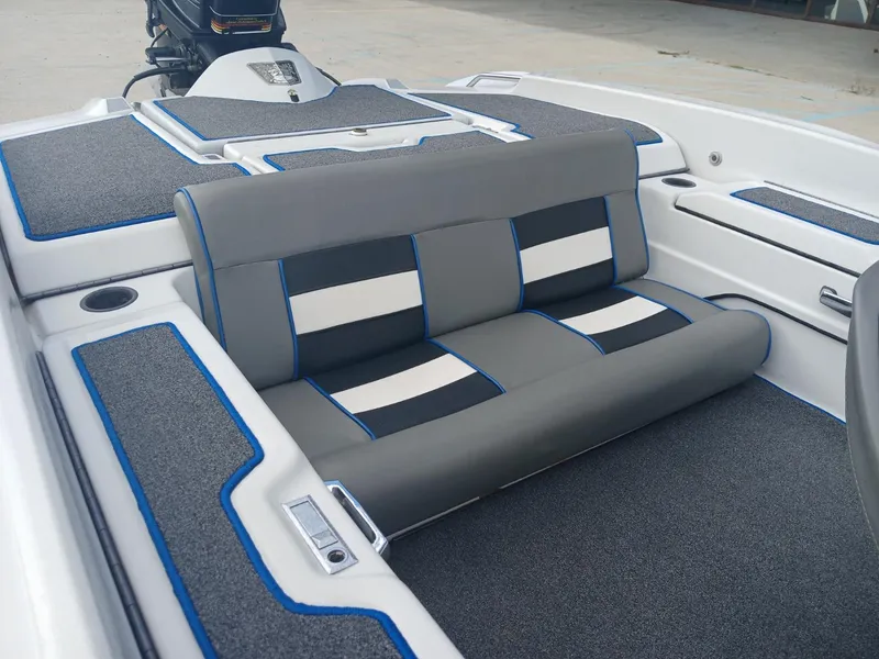 Slide: The Image of Allison 2002 XB boat interior with gray and white seating, blue accents, and carpeted flooring. - 14