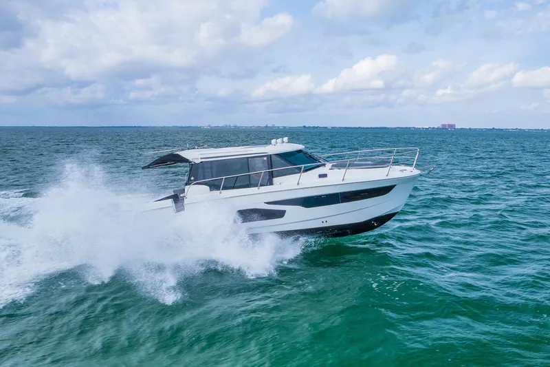 Slide: The Image of 2019 Jeanneau NC 1095 cruising on open water under a cloudy sky. - 11