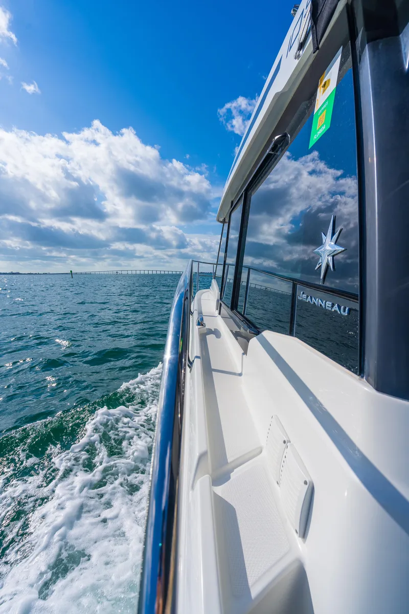 Slide: The Image of 2019 Jeanneau NC 1095 cruising on open water under a clear blue sky. - 15
