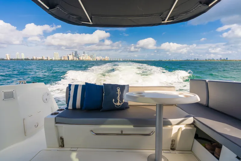Slide: The Image of Jeanneau NC 1095 boat interior with ocean view, 2019 model, featuring cushions and table. - 18