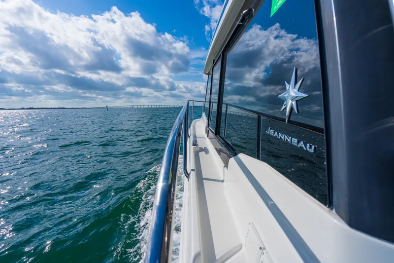 Slide: The Image of 2019 Jeanneau NC 1095 cruising on open water under a partly cloudy sky. - 19