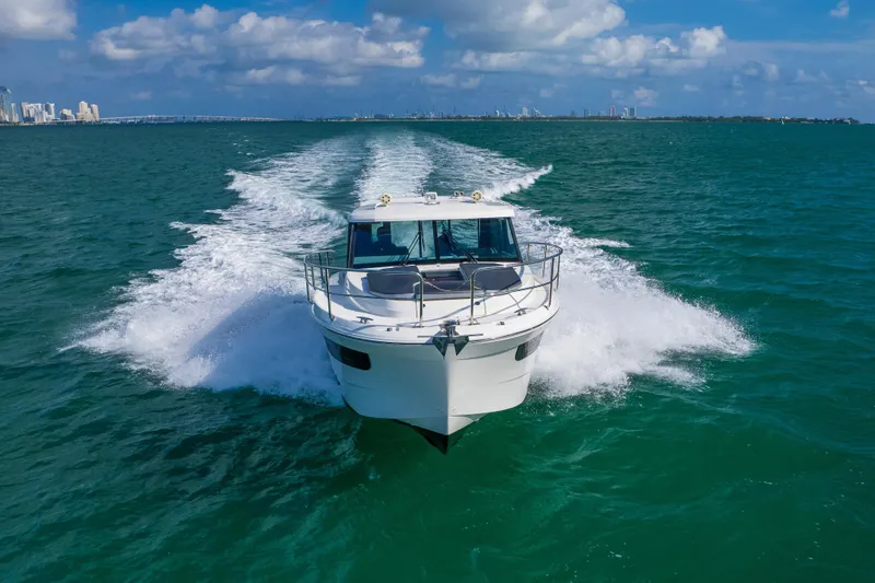 Slide: The Image of 2019 Jeanneau NC 1095 cruising on open water under a clear blue sky. - 2