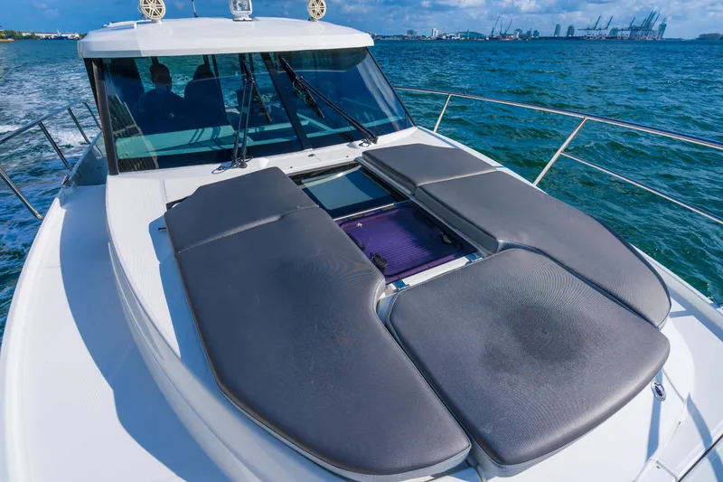 Slide: The Image of 2019 Jeanneau NC 1095 boat with sun pads on deck, cruising on open water. - 26