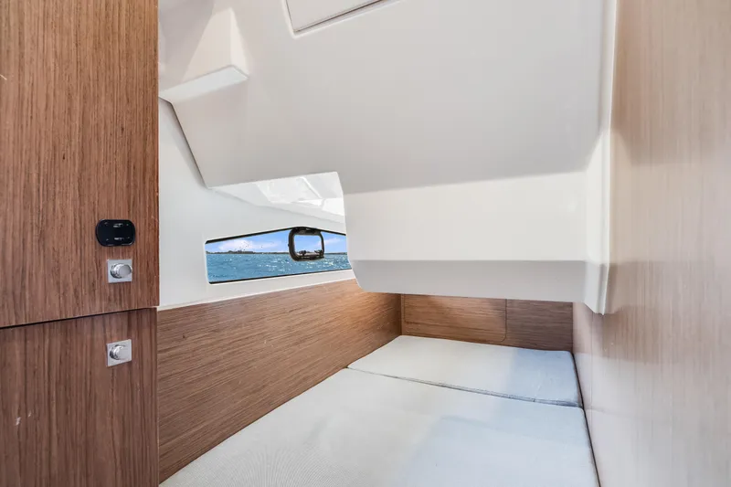 Slide: The Image of Interior cabin of 2019 Jeanneau NC 1095 boat with wood paneling and window view. - 27