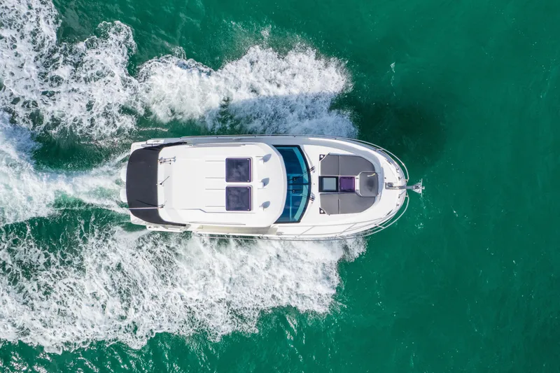 Slide: The Image of Aerial view of 2019 Jeanneau NC 1095 cruising on turquoise water. - 6
