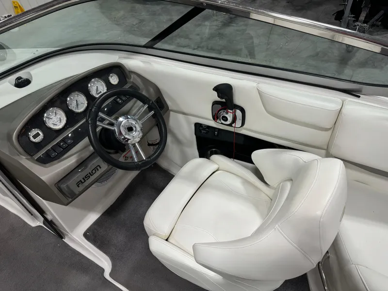 Slide: The Image of 2011 Regal 2500 LSR boat interior with steering wheel and white seating. - 15
