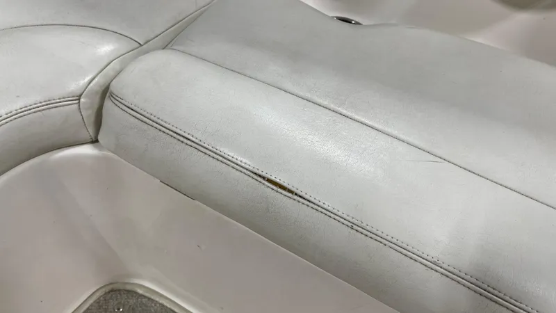 Slide: The Image of White leather seat in 2005 Chaparral 210 SSi boat, slight wear visible. - 20