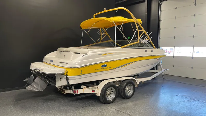 Slide: The Image of 2005 Chaparral 210 SSi boat with yellow accents on a trailer in a showroom. - 3