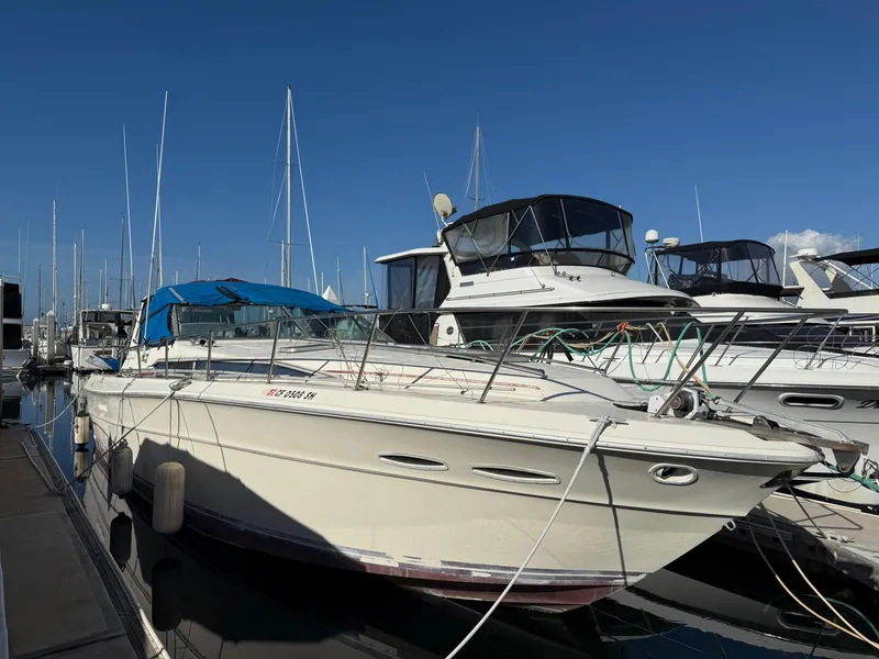 Slide: The Image of 1984 Sea Ray 390 Express Cruiser docked at marina under clear blue sky. - 0