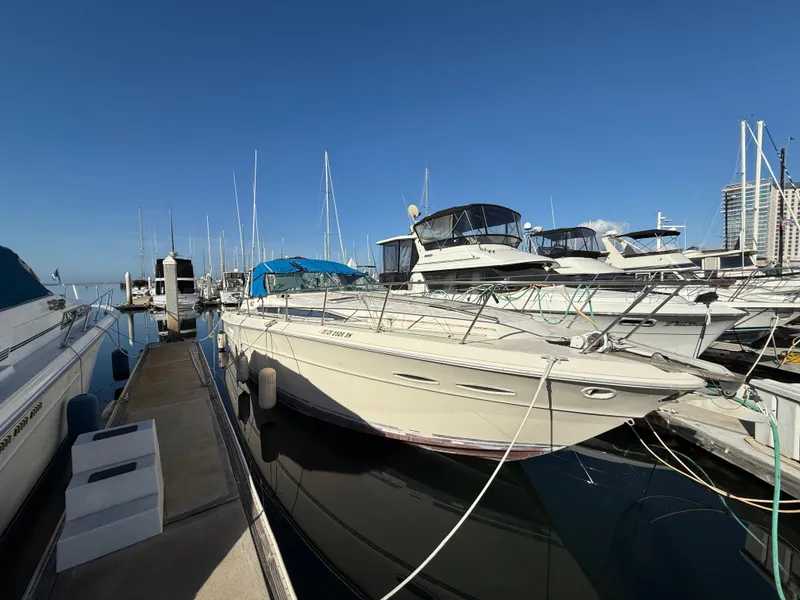 Slide: The Image of 1984 Sea Ray 390 Express Cruiser docked at marina under clear blue sky. - 1