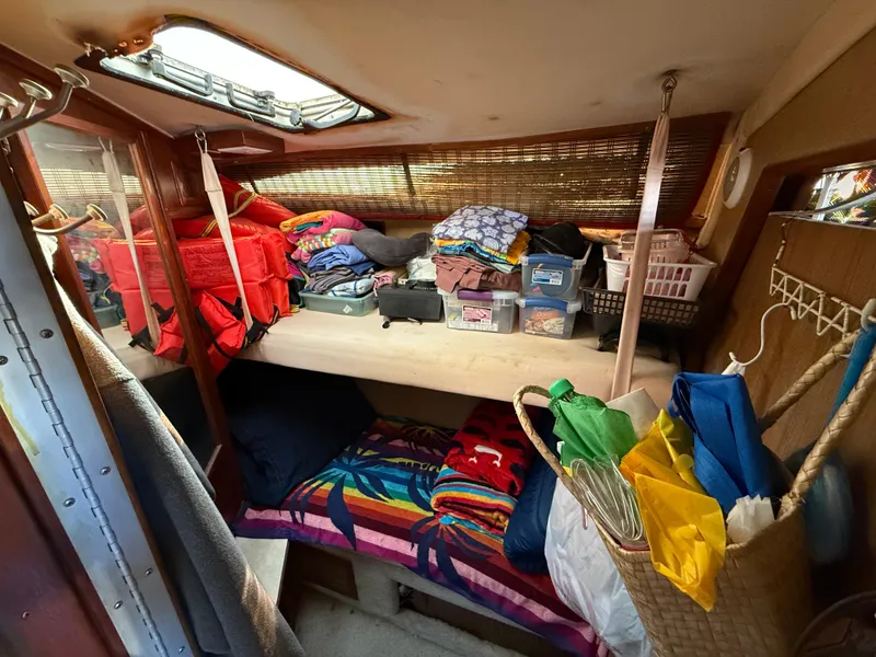 Slide: The Image of Cozy cabin interior of 1984 Sea Ray 390 Express Cruiser with organized storage and colorful bedding. - 16