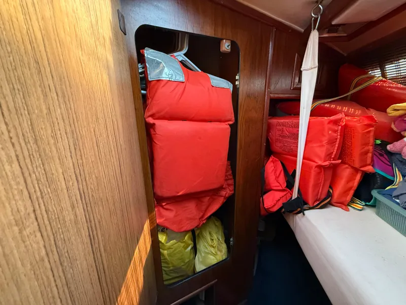 Slide: The Image of 1984 Sea Ray 390 Express Cruiser cabin with life jackets stored neatly. - 18