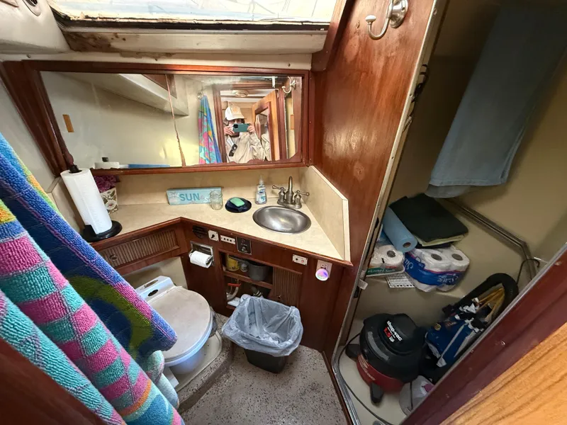 Slide: The Image of 1984 Sea Ray 390 Express Cruiser bathroom with sink, toilet, and storage shelves. - 20