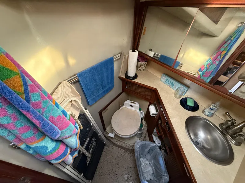 Slide: The Image of 1984 Sea Ray 390 Express Cruiser bathroom with sink, toilet, and colorful towels. - 21
