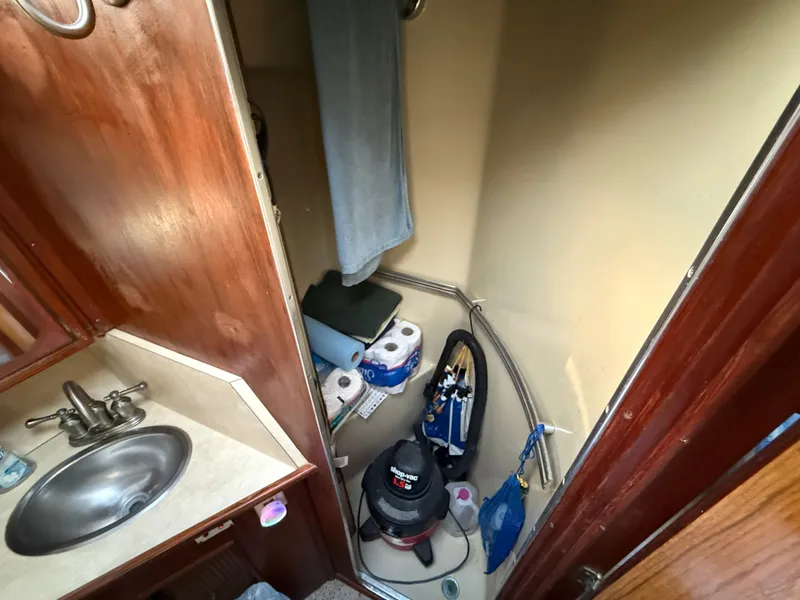 Slide: The Image of 1984 Sea Ray 390 Express Cruiser bathroom with sink, storage, and cleaning supplies. - 22