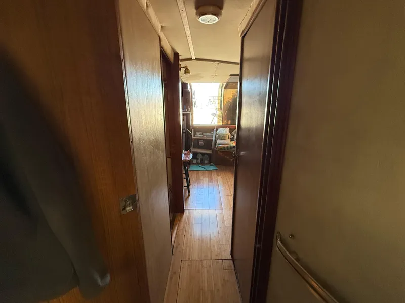 Slide: The Image of Interior hallway of 1984 Sea Ray 390 Express Cruiser with wooden flooring. - 23