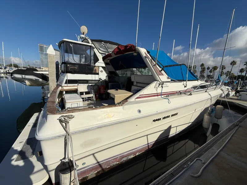 Slide: The Image of 1984 Sea Ray 390 Express Cruiser docked at marina under clear sky. - 3