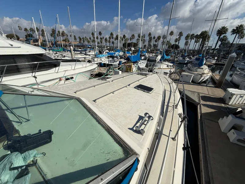 Slide: The Image of 1984 Sea Ray 390 Express Cruiser docked in a marina with sailboats. - 8