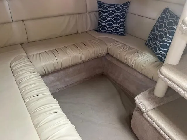 Slide: The Image of Interior seating area of 2000 Sea Ray 340 Sundancer with beige cushions and blue pillows. - 10