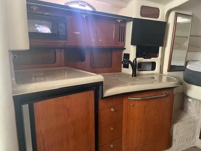 Slide: The Image of 2000 Sea Ray 340 Sundancer interior kitchen with wood cabinets and modern appliances. - 11
