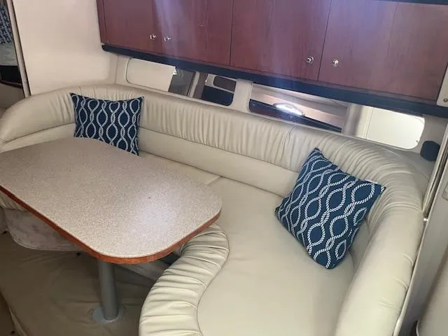 Slide: The Image of Interior of 2000 Sea Ray 340 Sundancer with cushioned seating and table. - 13